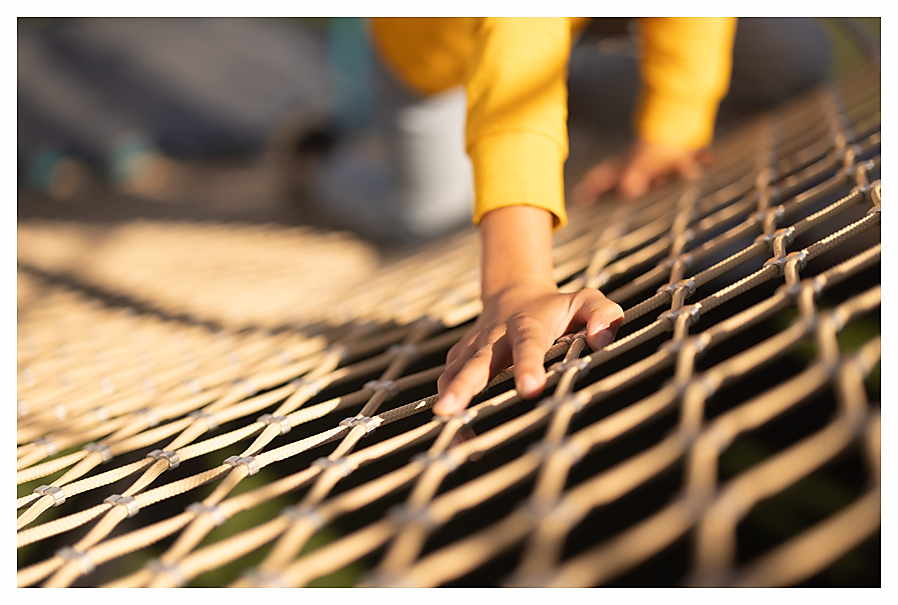 Child's hand on climbing net