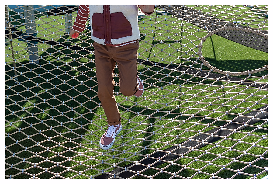 Child walking across climbing net